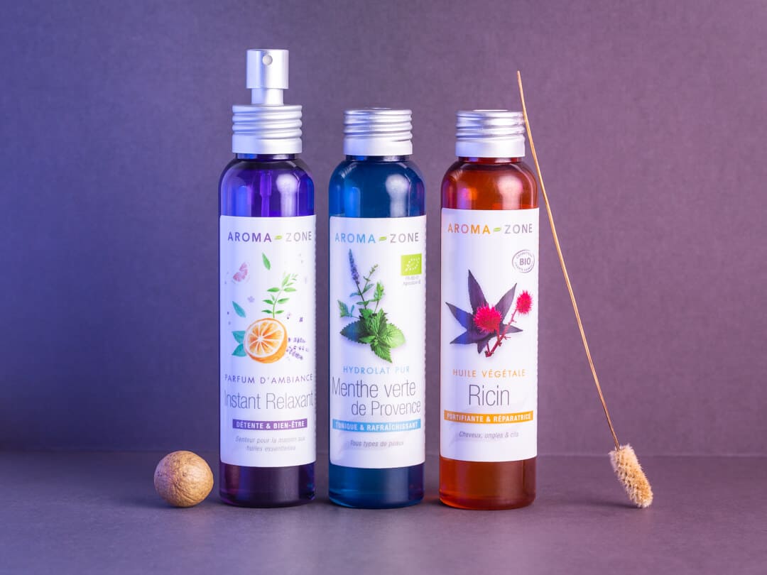 Photographie de produits avec des éléments naturels sur un fond dégradé du violet au rose