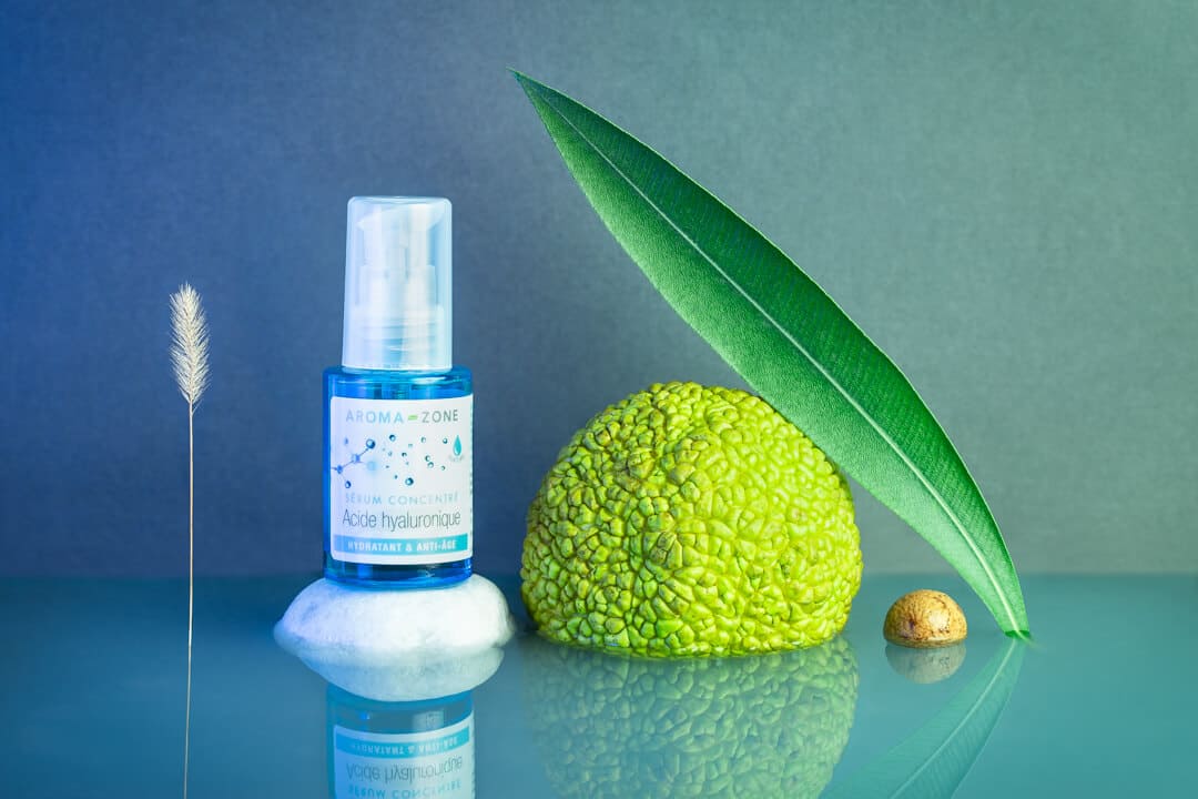 Photographie de mise en scène produit avec des végétaux  disposés sur de l'eau et un fond dégradé bleu